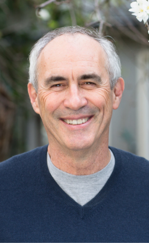 A man with grey hair and wearing a gray shirt.